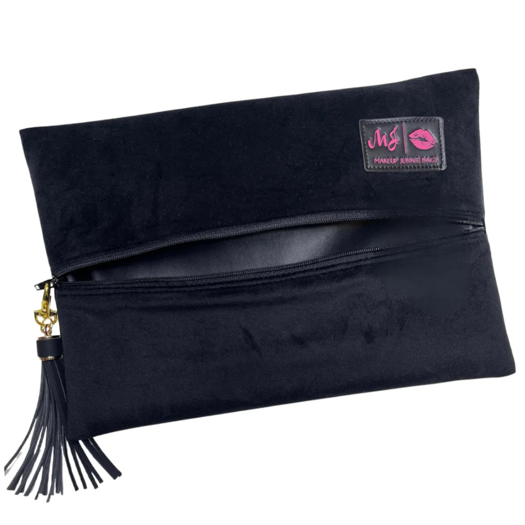 Elegant black velvet Audrey Hepburn Makeup Junkie travel bag with gold hardware and tassel zipper pull, flat‑lay design and velvet exterior.
