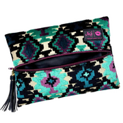 Front view of Aztec Emerald Makeup Junkie bag in teal velvet with bold Aztec-print exterior, purple zipper and branded tassel accent.