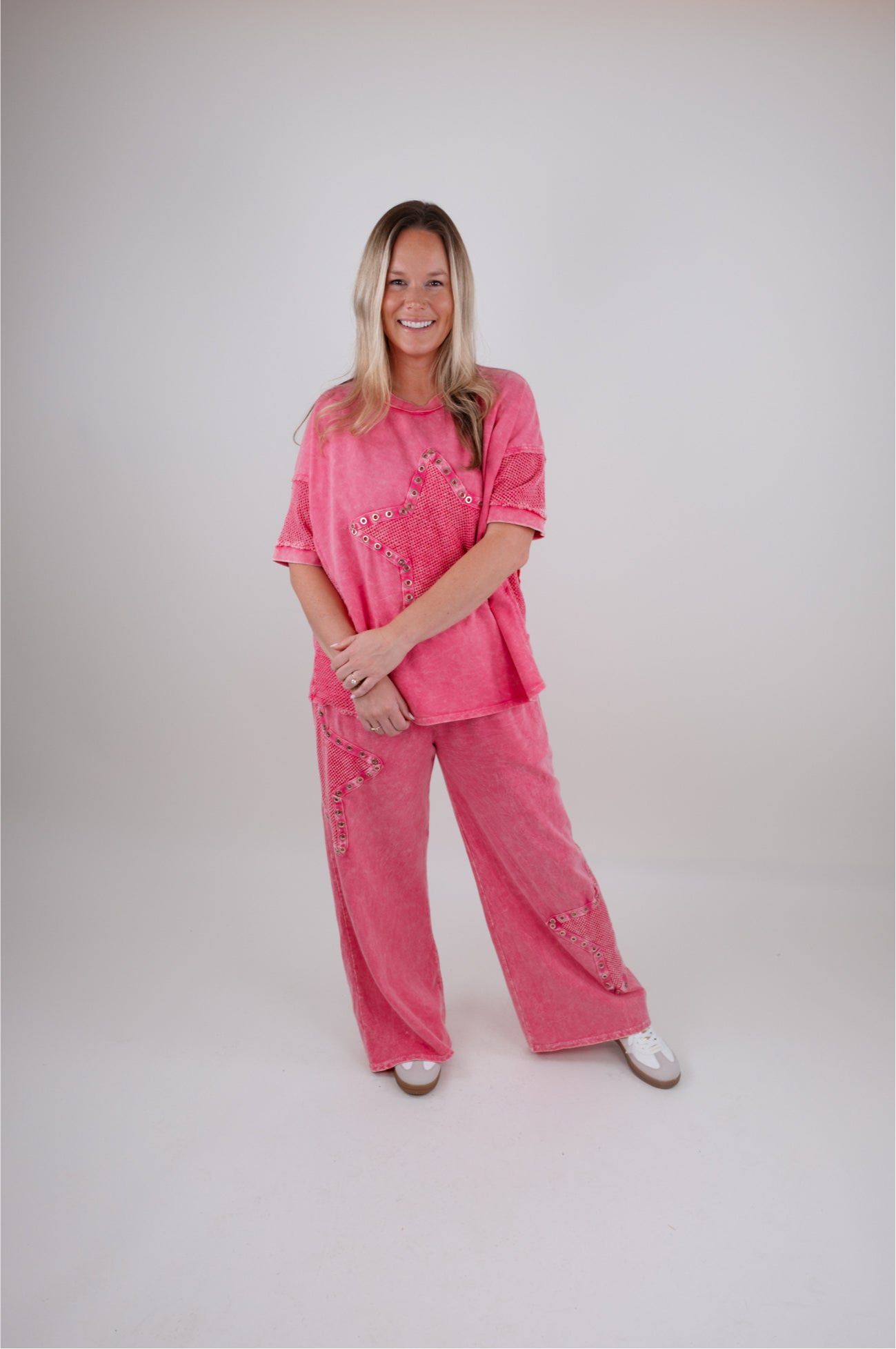 Woman wearing a pink outfit with star patterns on a white background