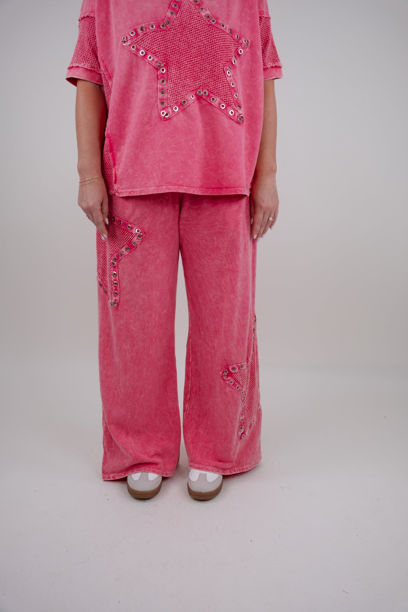 Person wearing a pink outfit with star elements on a plain background