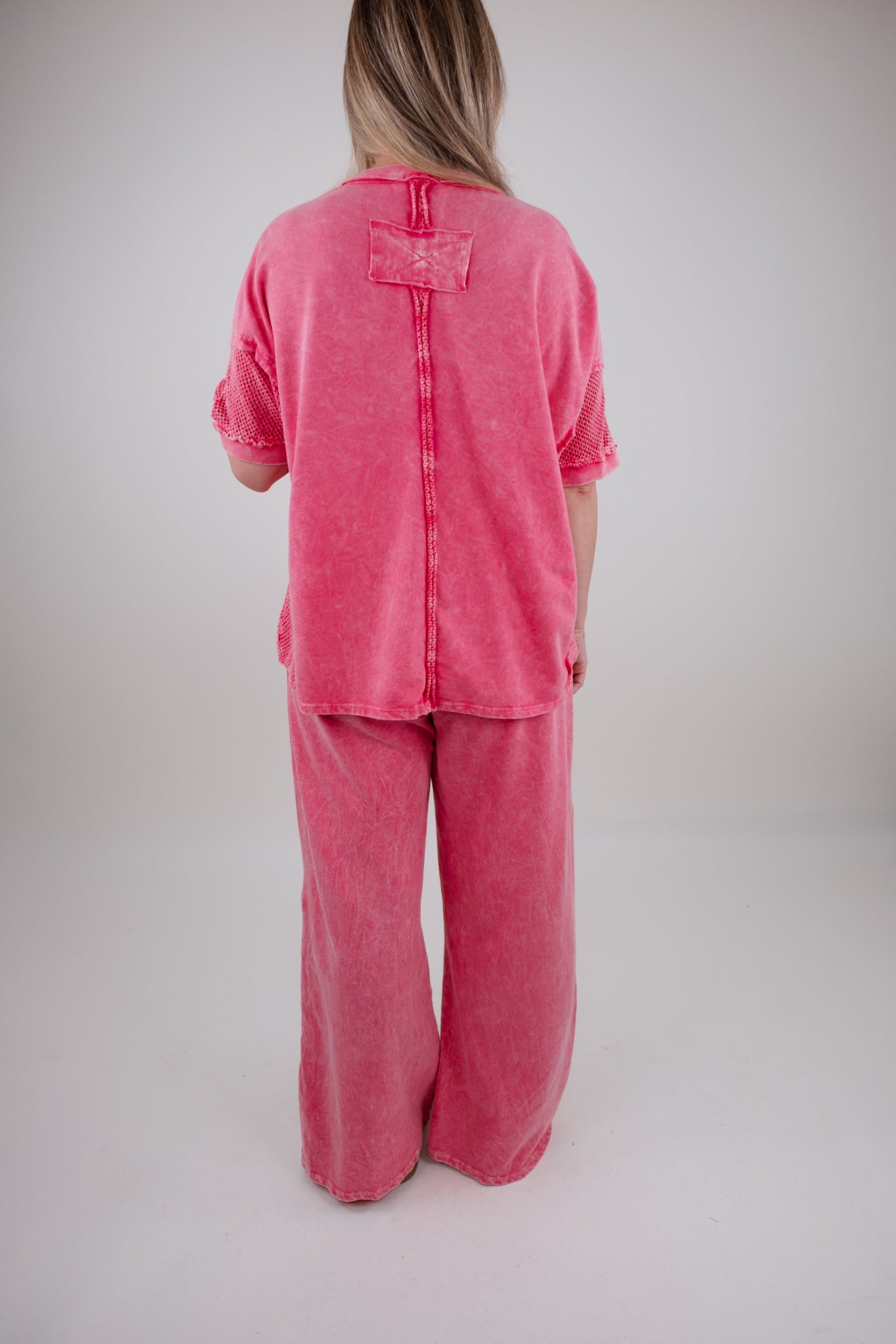 Person wearing a pink outfit set on a plain background