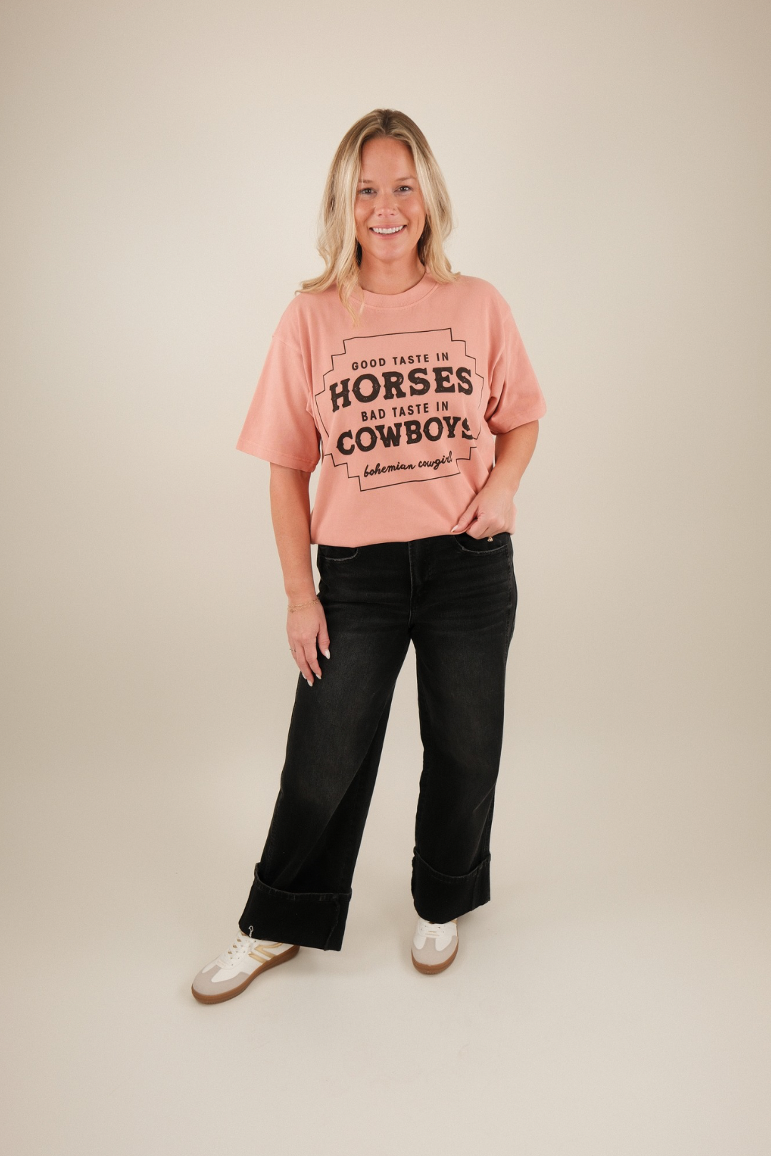 Model wearing Black Stallion Utility Jeans with graphic tee, showcasing high‑rise waist, boxy fit, cuffed hem and western street style flair.