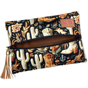 Front view of Boot Babe travel bag featuring chocolate‑brown western boot print on tan backdrop, black zipper and gold tassel pull.