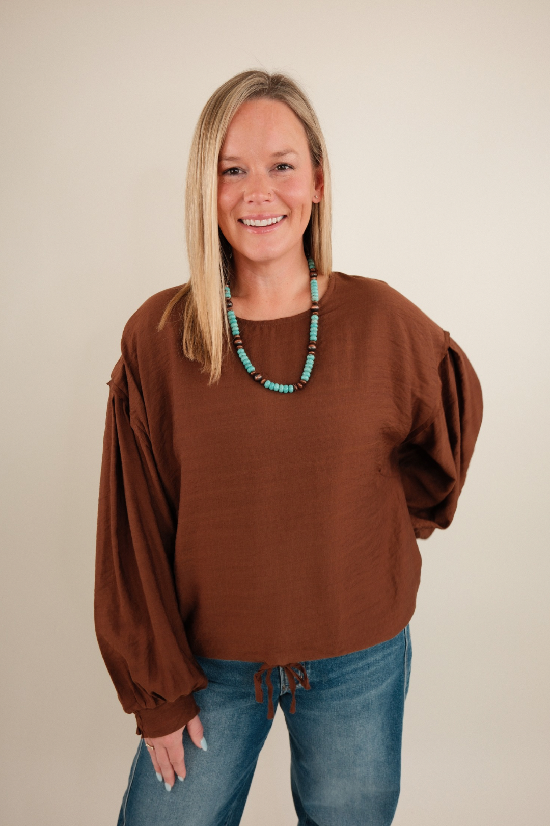 Front view of Bronco Brown Blouse in warm chocolate with rounded neckline, bubble sleeves and western-inspired design.