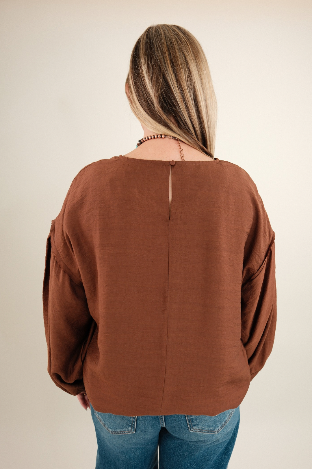 Back view of Bronco Brown Blouse in rich brown with bubble sleeves, keyhole detail and western-inspired tailoring.