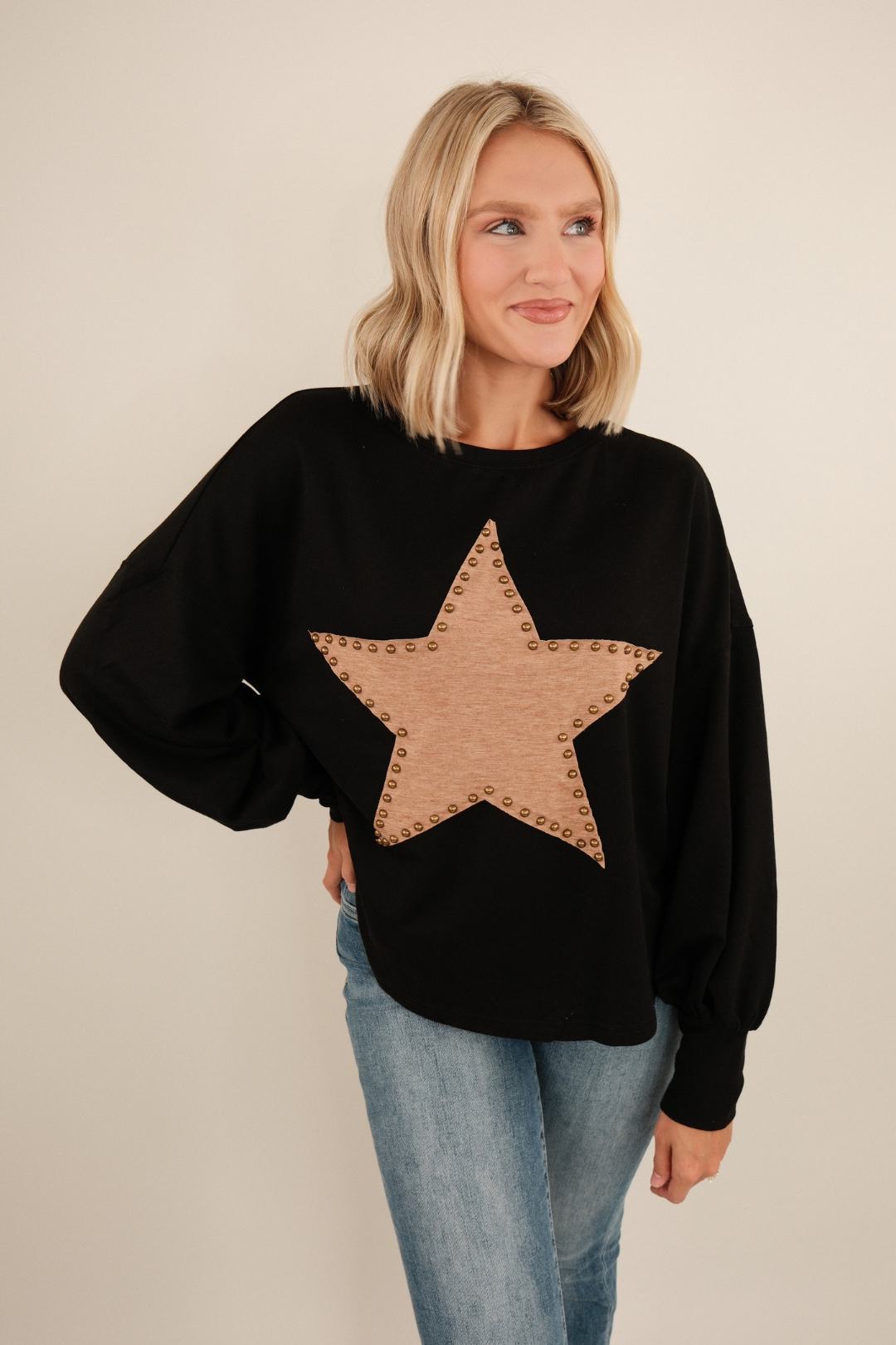 Black knit Bronze Star pullover with brown star motifs, relaxed western fit and soft sweater texture.