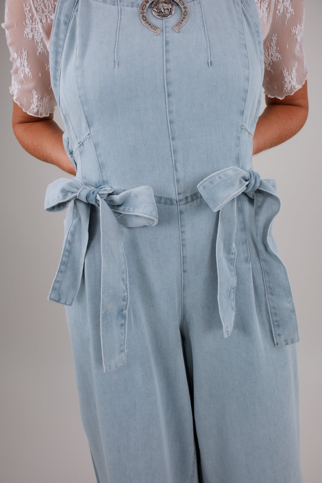 Light blue denim jumpsuit with a plain background
