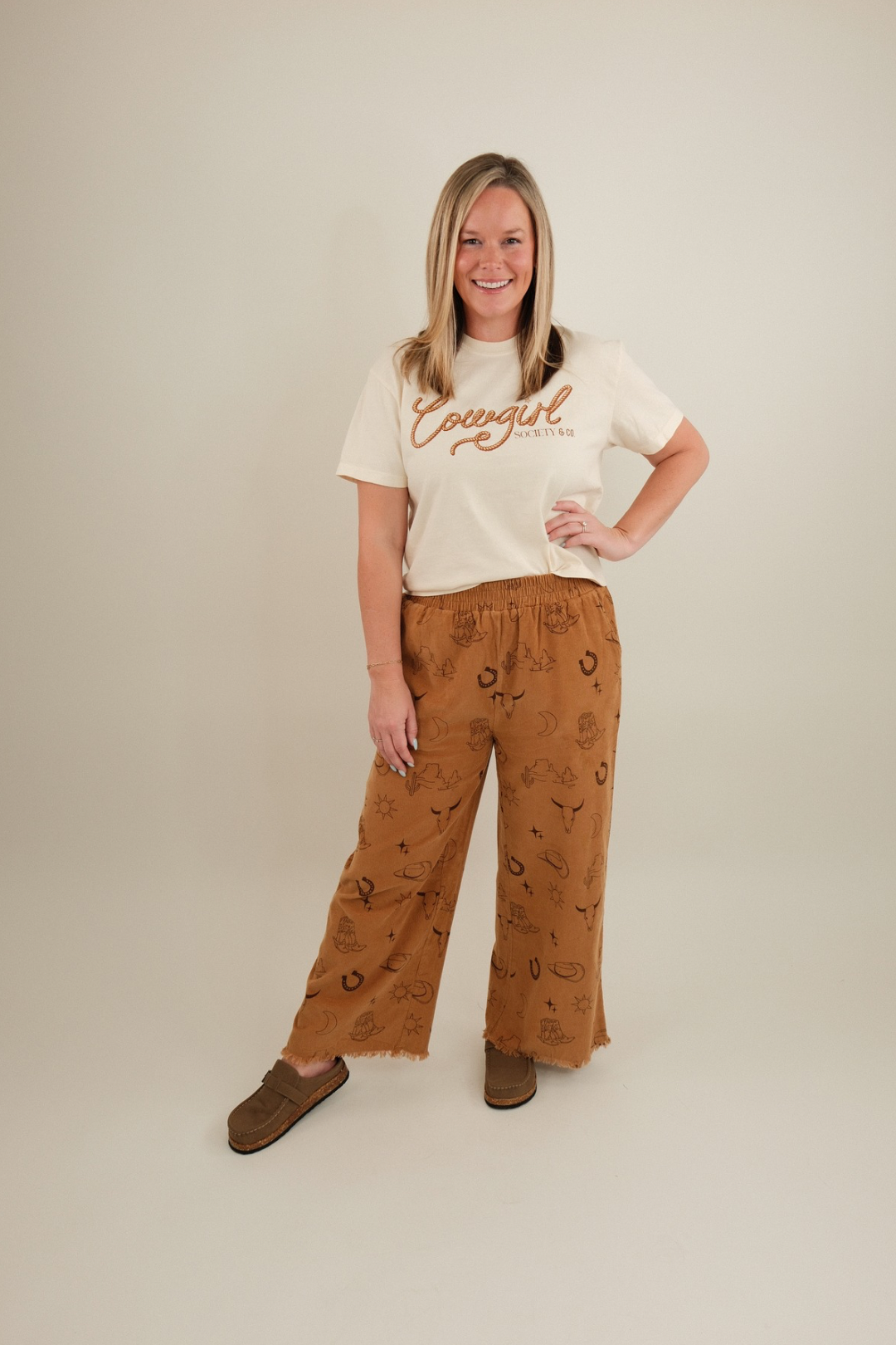Wide-leg pull-on corduroy pants with western motif print, elastic waistband, roomy pockets in camel.