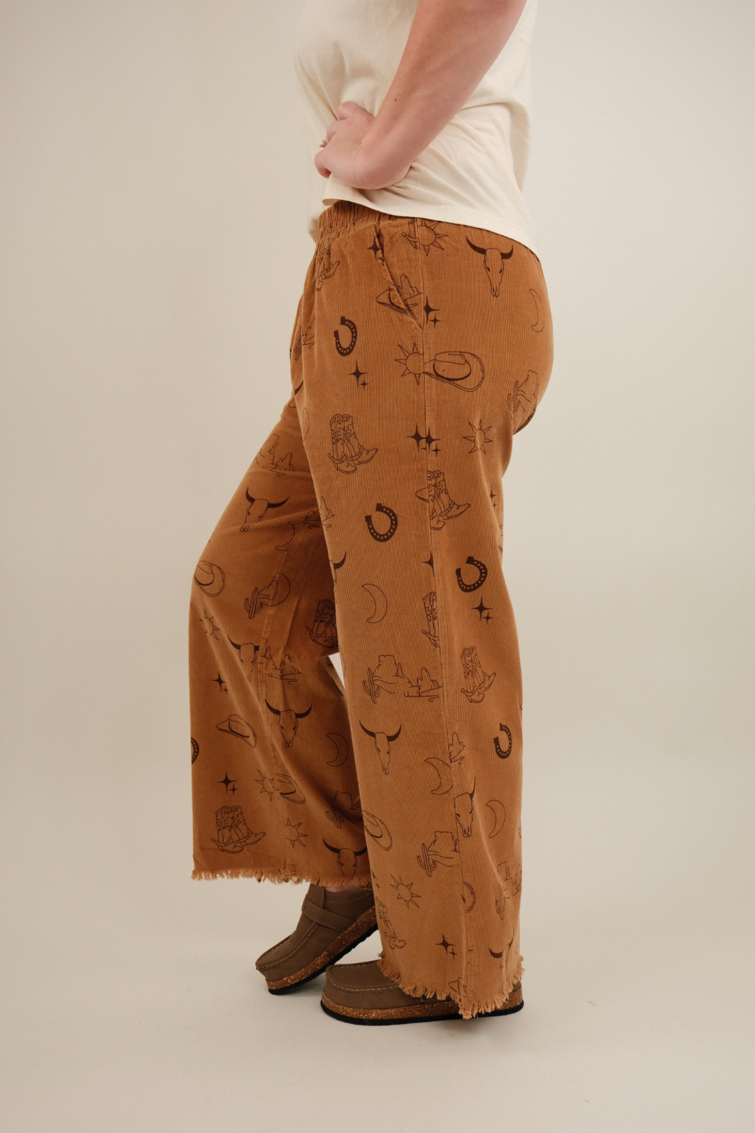 Side profile of camel Canyon Creek Corduroy Pants showing relaxed wide-leg cut and western motif corduroy design.