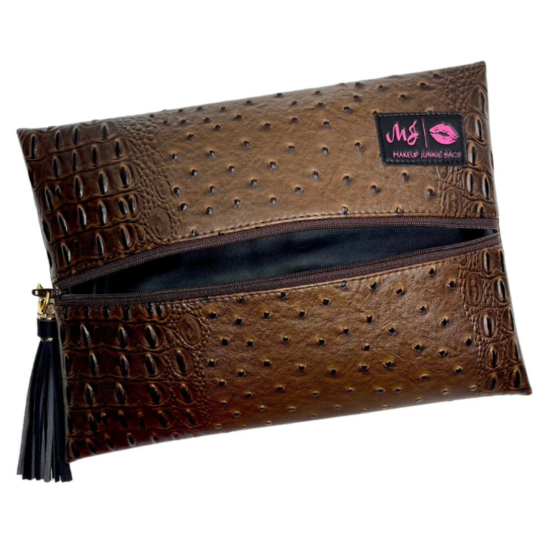 Front view of Chocolate Dune Makeup Junkie bag featuring wave‑textured chocolate brown and taupe faux‑leather with brown zipper.