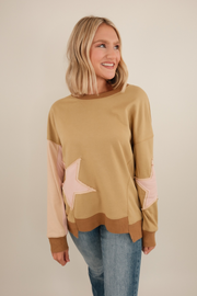 Front view of Cosmic Cowgirl Pullover in tan, lightweight relaxed-fit top with bold star patches on chest and western-inspired design.