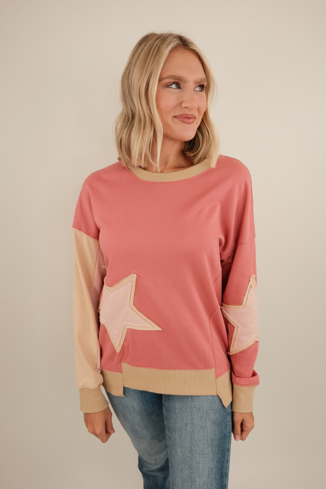 Front view of Cosmic Cowgirl Pullover in rose, lightweight relaxed-fit top with bold star patches on chest and western-inspired design.