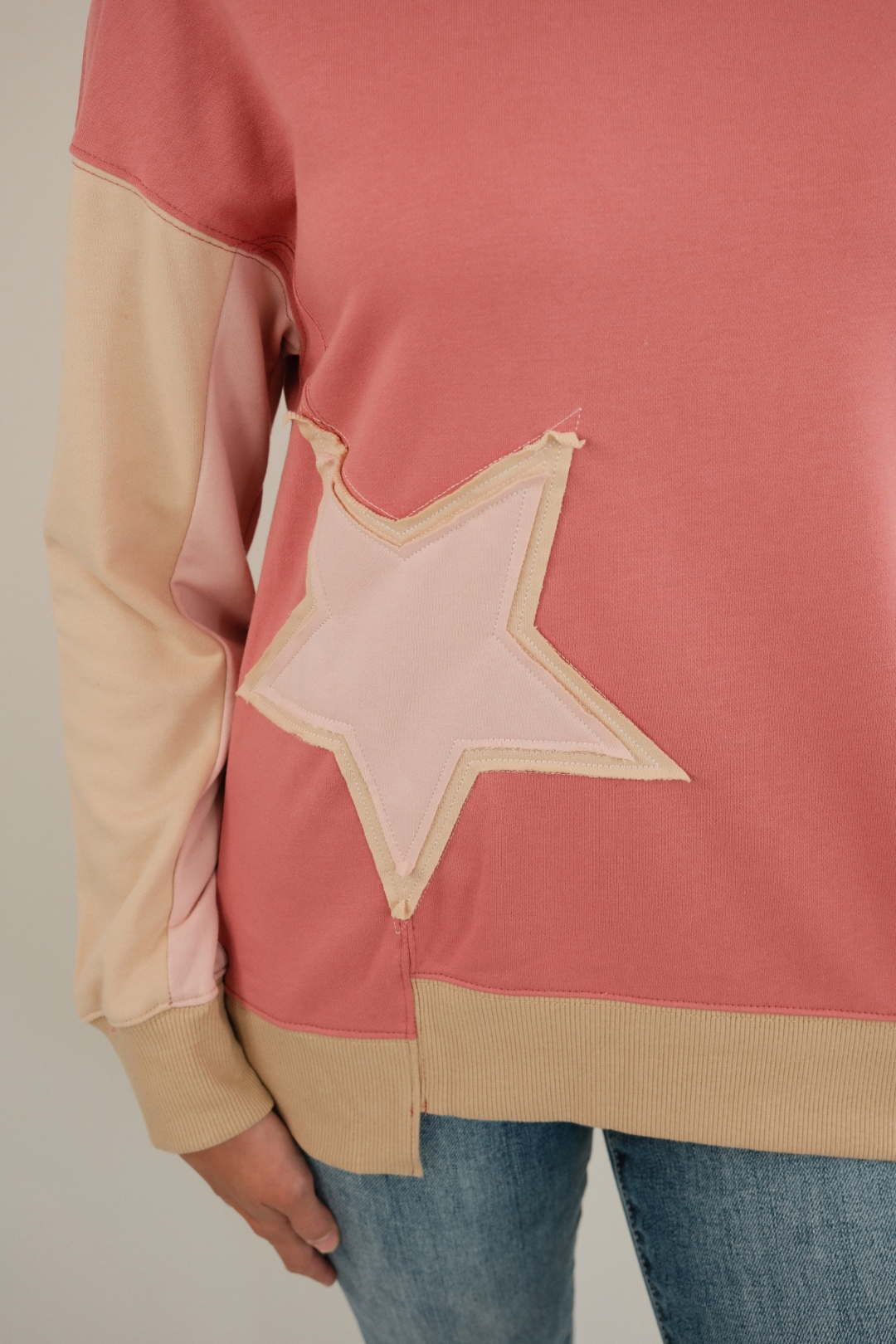 Detail shot of Cosmic Cowgirl Pullover highlighting star patch embroidery and contrast sleeve design in rose western pullover.