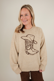 Front view of Cowgirl Classic Sweater, soft beige knit with brown cowboy hat and boot design, relaxed fit, and classic western style.