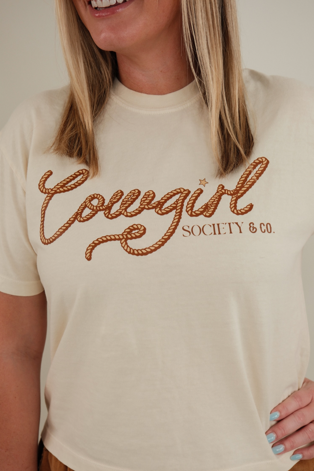 Front view of Cowgirl Connection Cropped Tee, raw hem western crop top with bold graphic and relaxed cowgirl style.