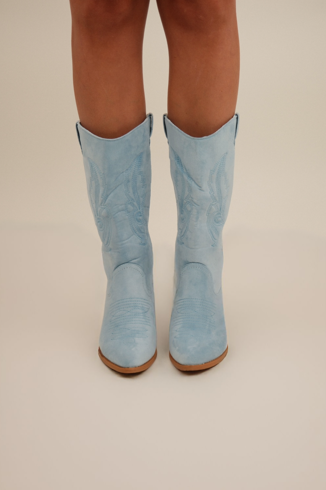 Front view of Cowgirl Pop Suede Boots, dreamy light blue suede with decorative embroidery and mid-height heel.