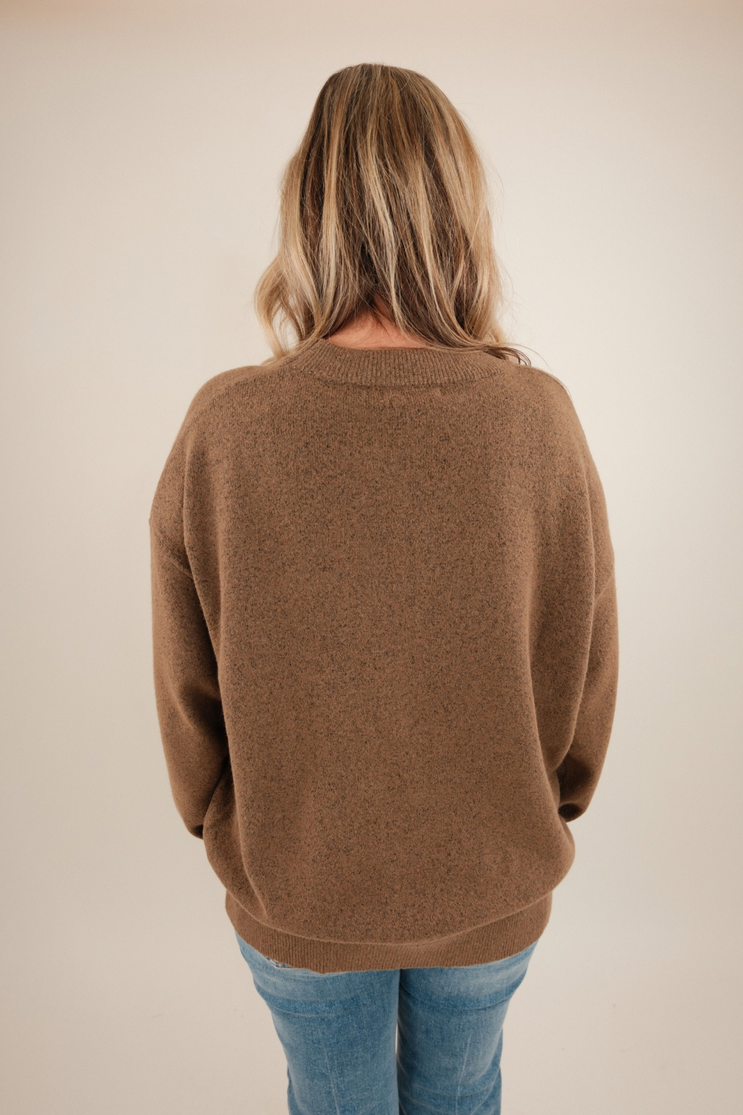 Back view of warm brown Cowgirl’s Luck Sweater highlighting plush knit texture and cream horseshoe accent for cowgirl charm.