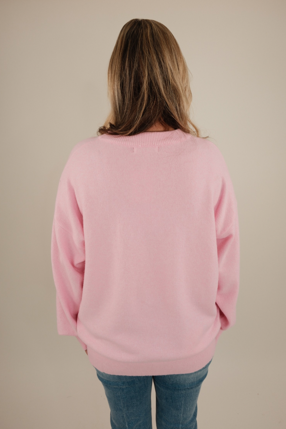 Back view of blush pink Cowgirl’s Luck Sweater showing cozy knit texture, cream horseshoe accent, and relaxed flattering fit.