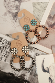 Pair of beaded earrings on a vintage-style card with a rustic background