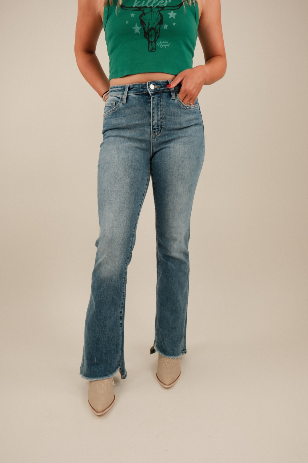 Front view of Dusty Trail Slant Flare Jeans in medium wash denim with slanted front hem, high‑rise waist and subtle flare leg.