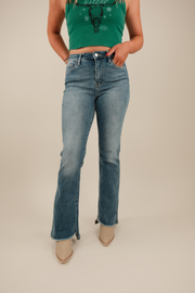 Front view of Dusty Trail Slant Flare Jeans in medium wash denim with slanted front hem, high‑rise waist and subtle flare leg.