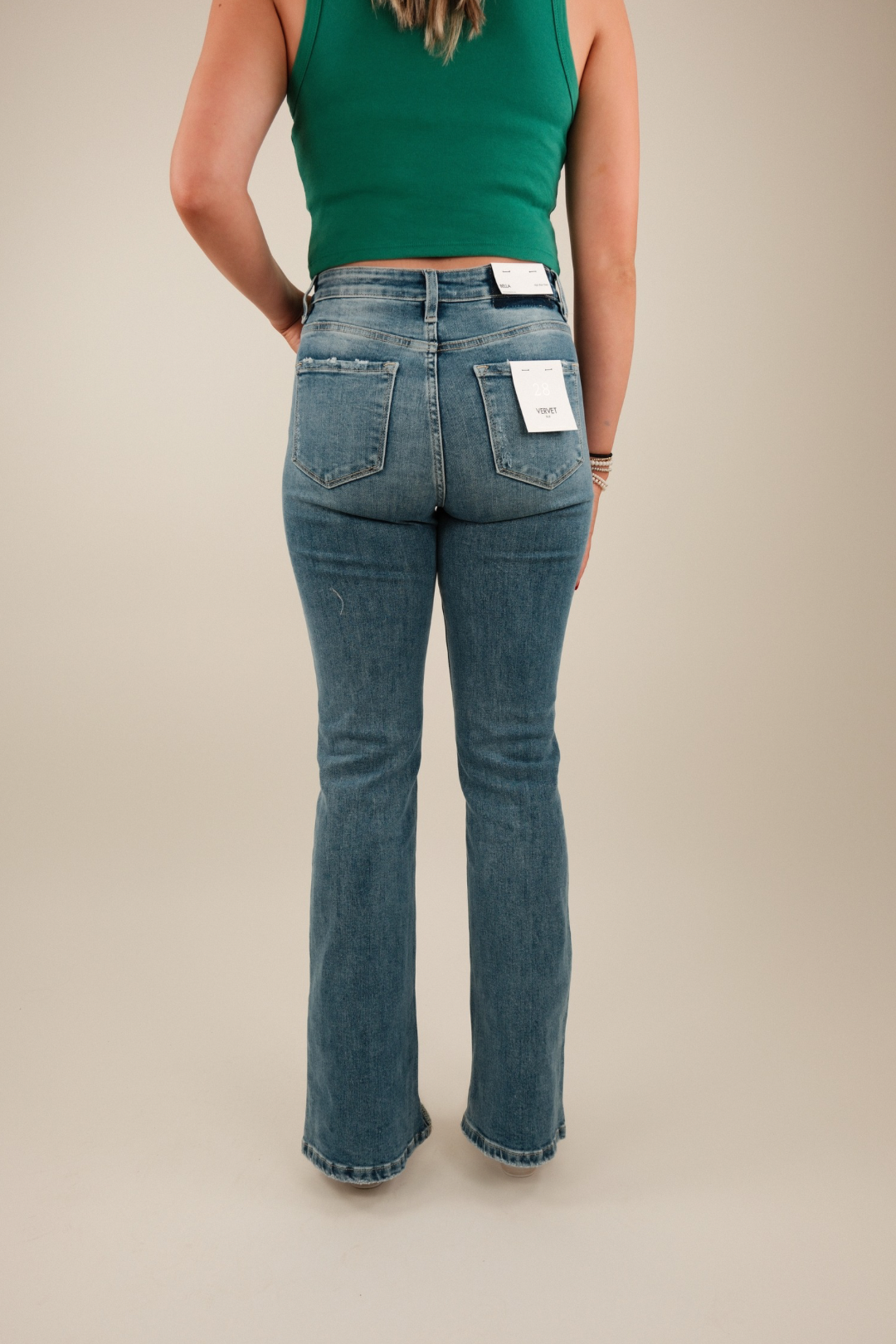 Back view showing classic five‑pocket styling, high‑rise denim waist and flared hem, perfect for pairing with cowboy boots.