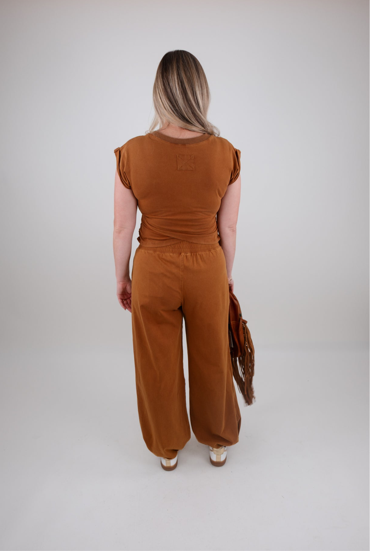 Person wearing a brown outfit set on a plain background