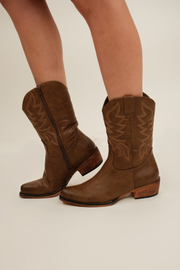 Taupe western-style Ember boots with pointed toe, decorative stitching, and 2.5-inch stacked heel.