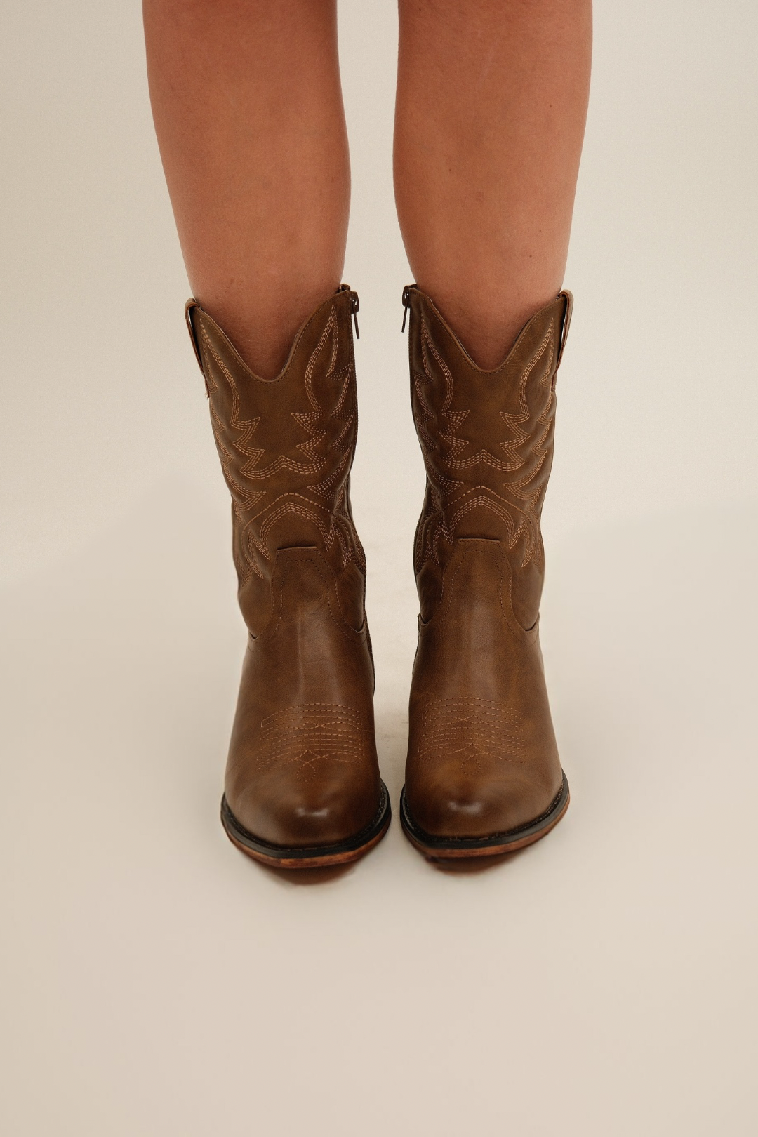 Front View of Ember Range cowgirl boots in taupe suede highlighting embroidery, pointed toe and stacked heel.