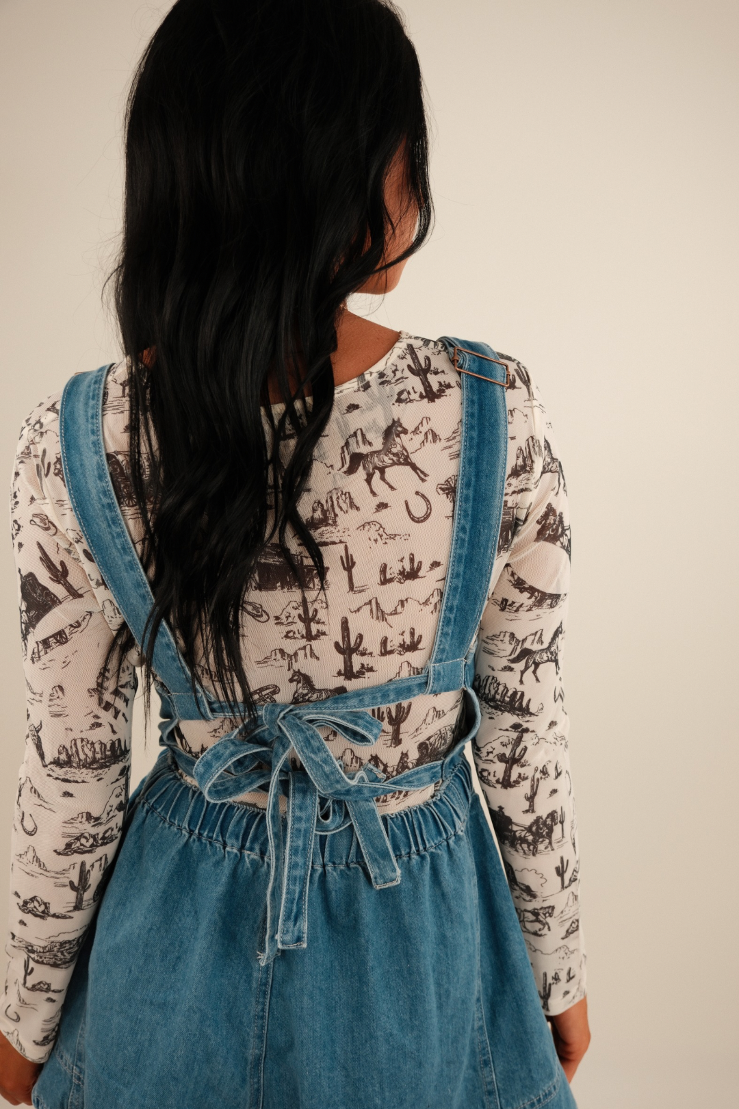 Back of the sheer mesh top with the western motif continuing across the shoulders and arms, showing full print detail and lightweight drape.