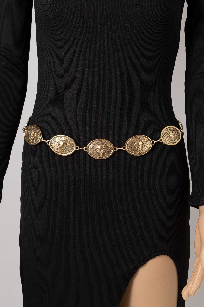 Black dress with a gold circular chain belt featuring bull skull designs on a neutral background