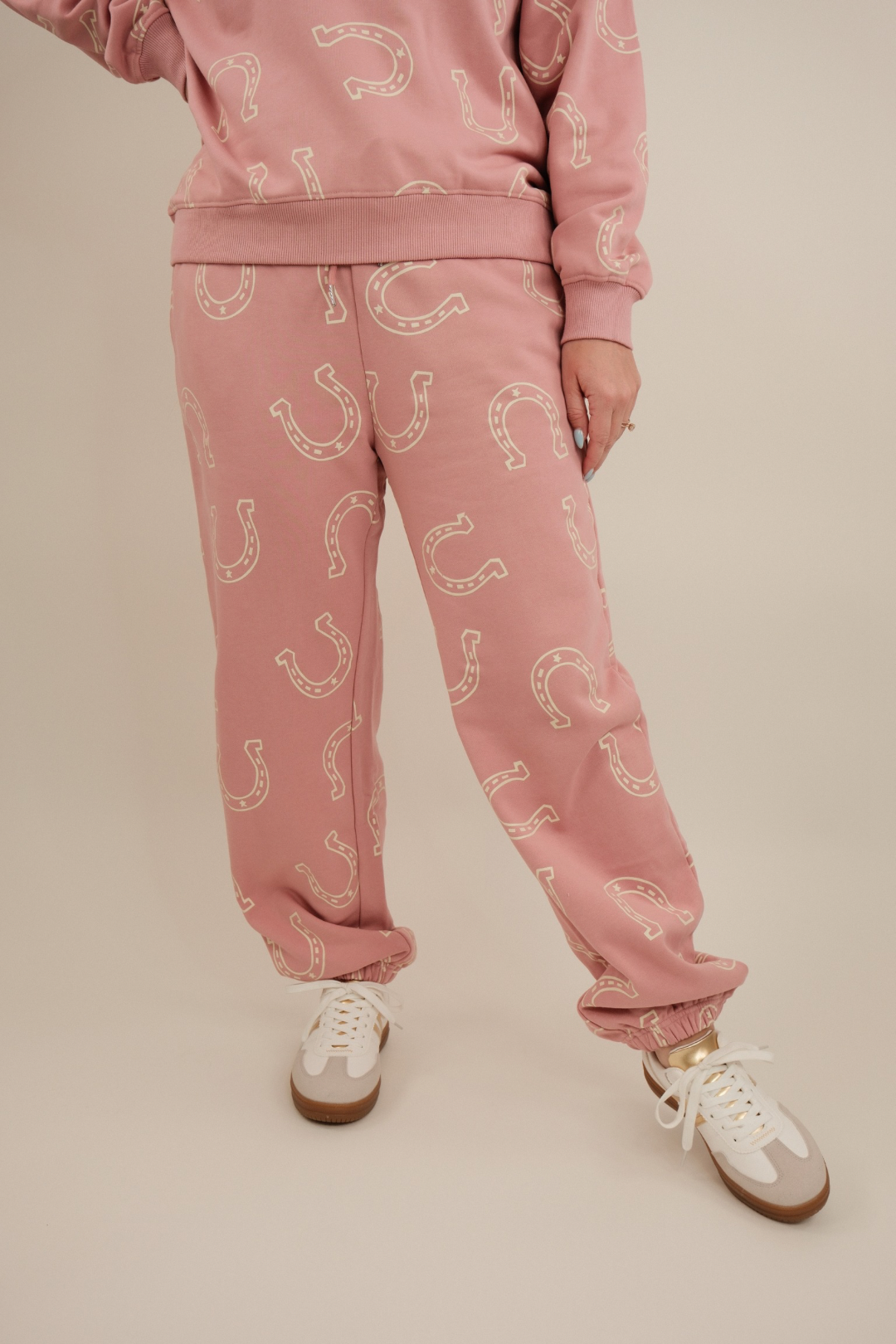 Close-up of Horseshoe Haven Lounge Set highlighting soft mauve knit fabric with cream horseshoe motif and jogger drawstring waist.