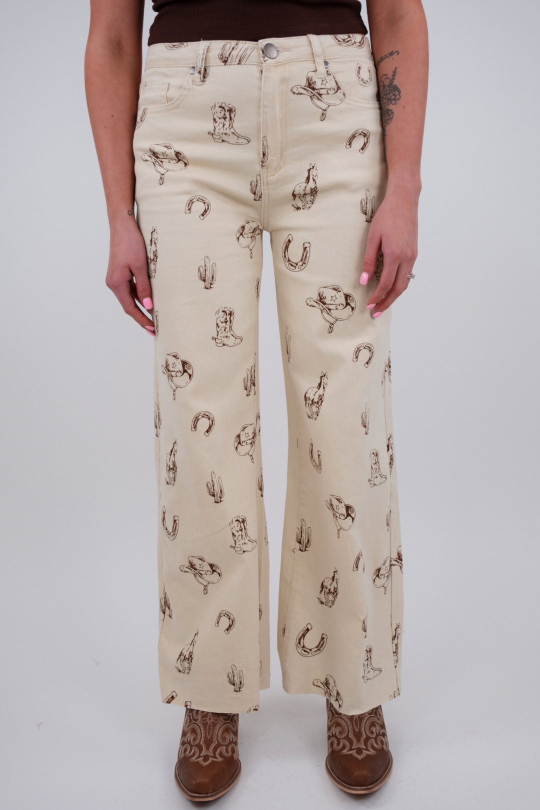 Person wearing cream-colored pants with horse print on a white background