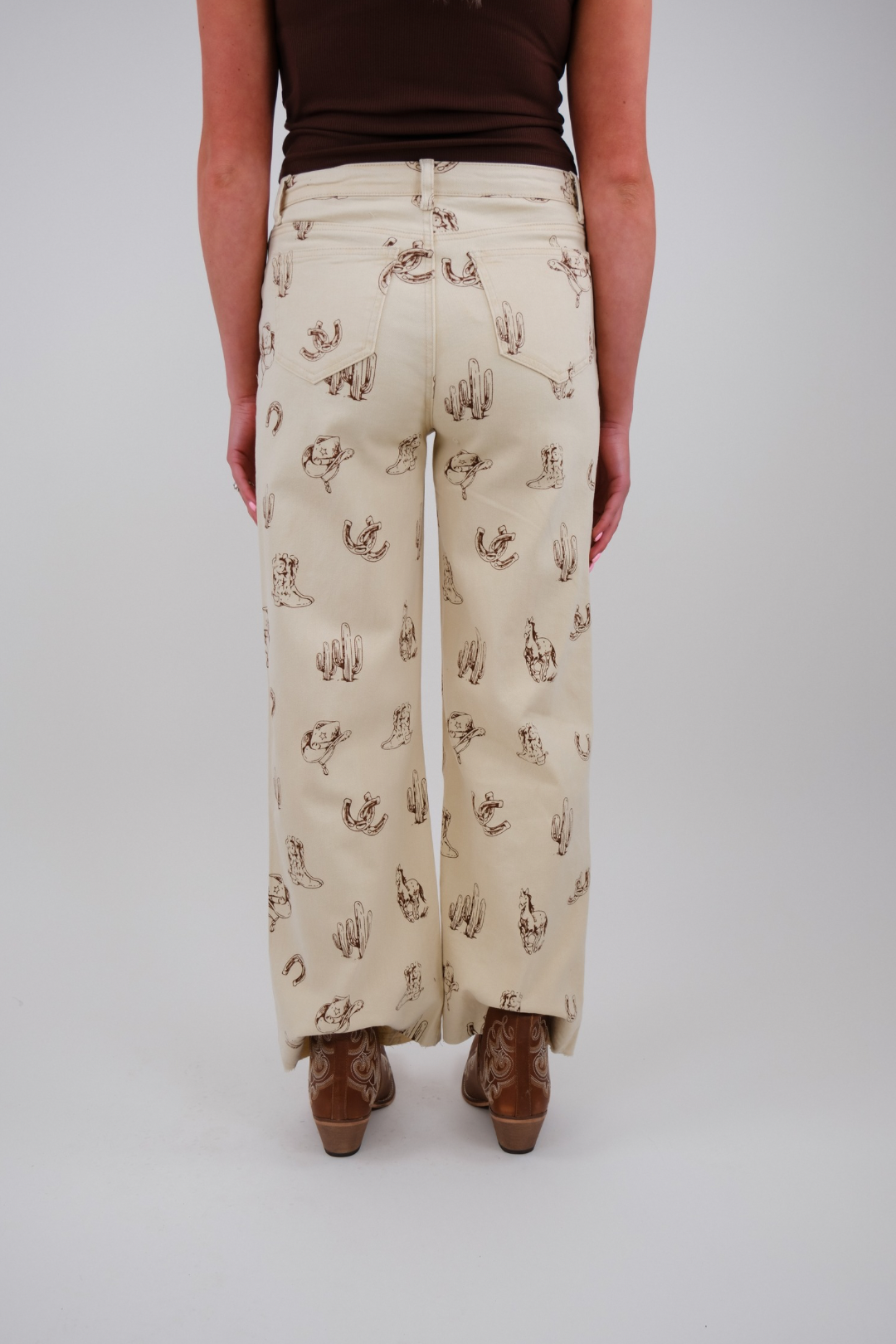 Person wearing cream-colored pants with cactus pattern on a plain background