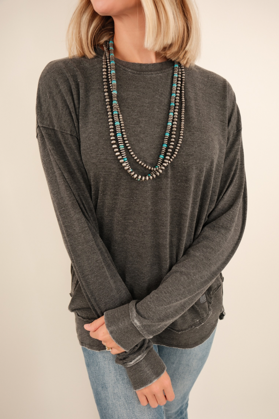 Close-up of Vintage Washed Poncho Tee highlighting charcoal fabric, vintage wash texture and poncho sleeve detail.