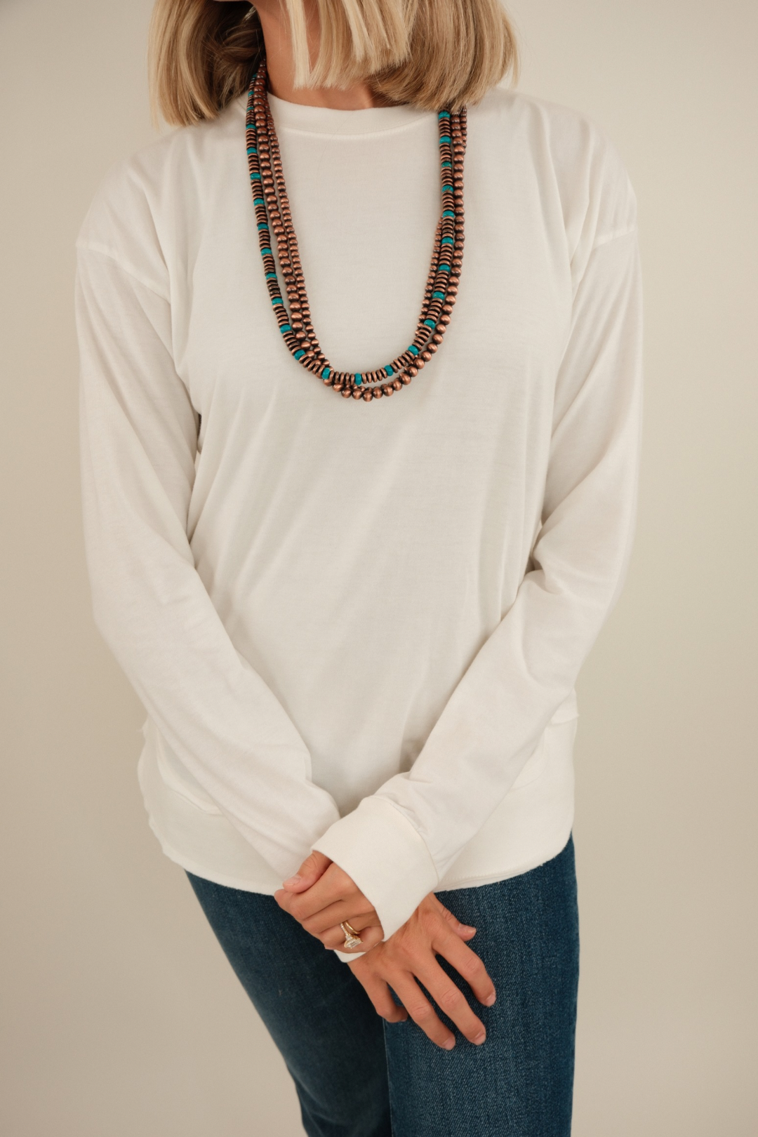 Close-up of Vintage Washed Poncho Tee highlighting ivory fabric, vintage wash texture and poncho sleeve detail.