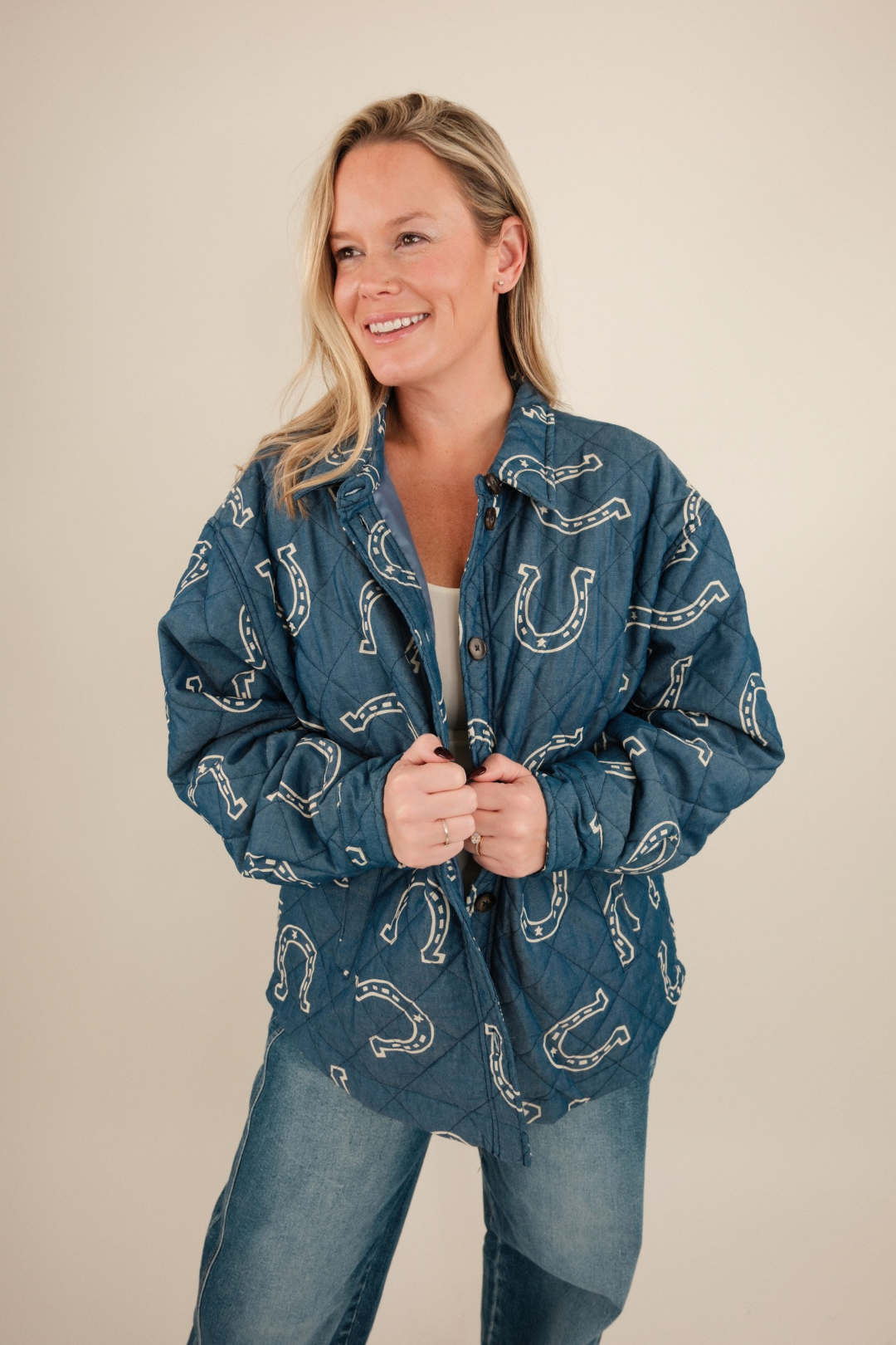 Front view of Lucky Stitch Quilted Denim Jacket, medium wash denim with cream horseshoe print, collared neckline, and quilted texture.