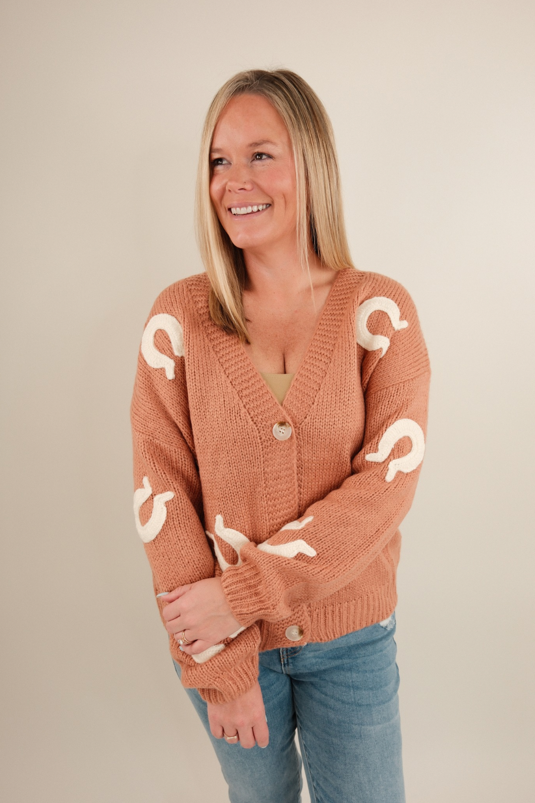Soft knit cardigan in terra cotta with stitched cream horseshoes all over, button-up front, slightly oversized western layering piece
