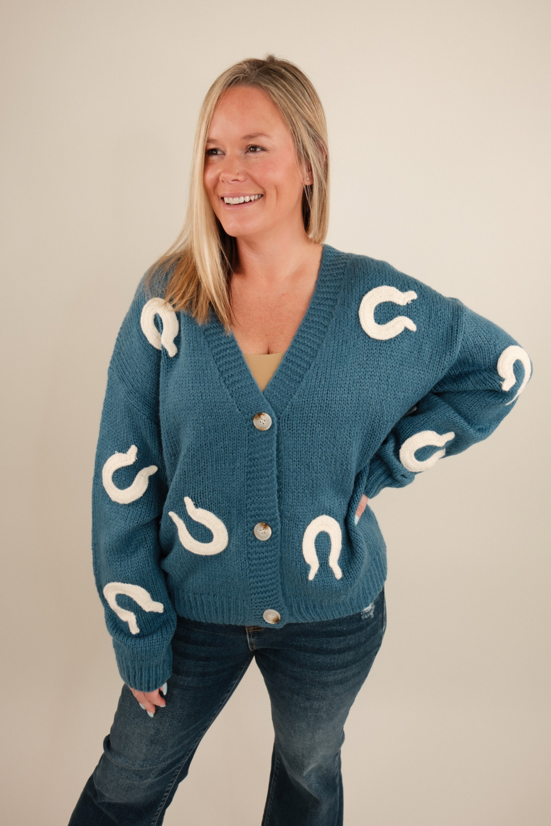 Soft knit cardigan in denim blue with stitched cream horseshoes all over, button-up front, slightly oversized western layering piece.