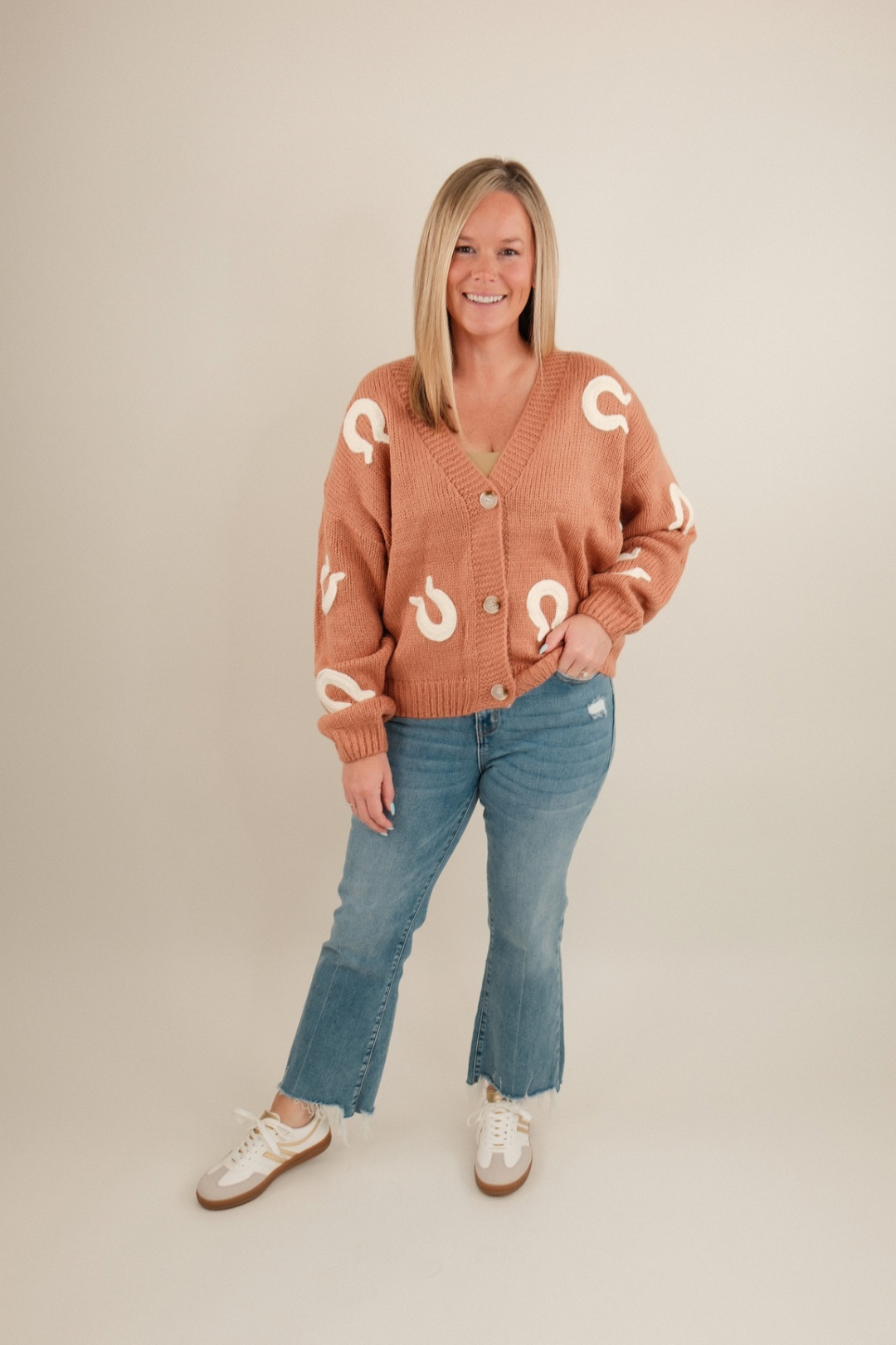 Front view of Lucky Stitches Cardigan, terra cotta knit with cream horseshoe stitching and button-up western style.