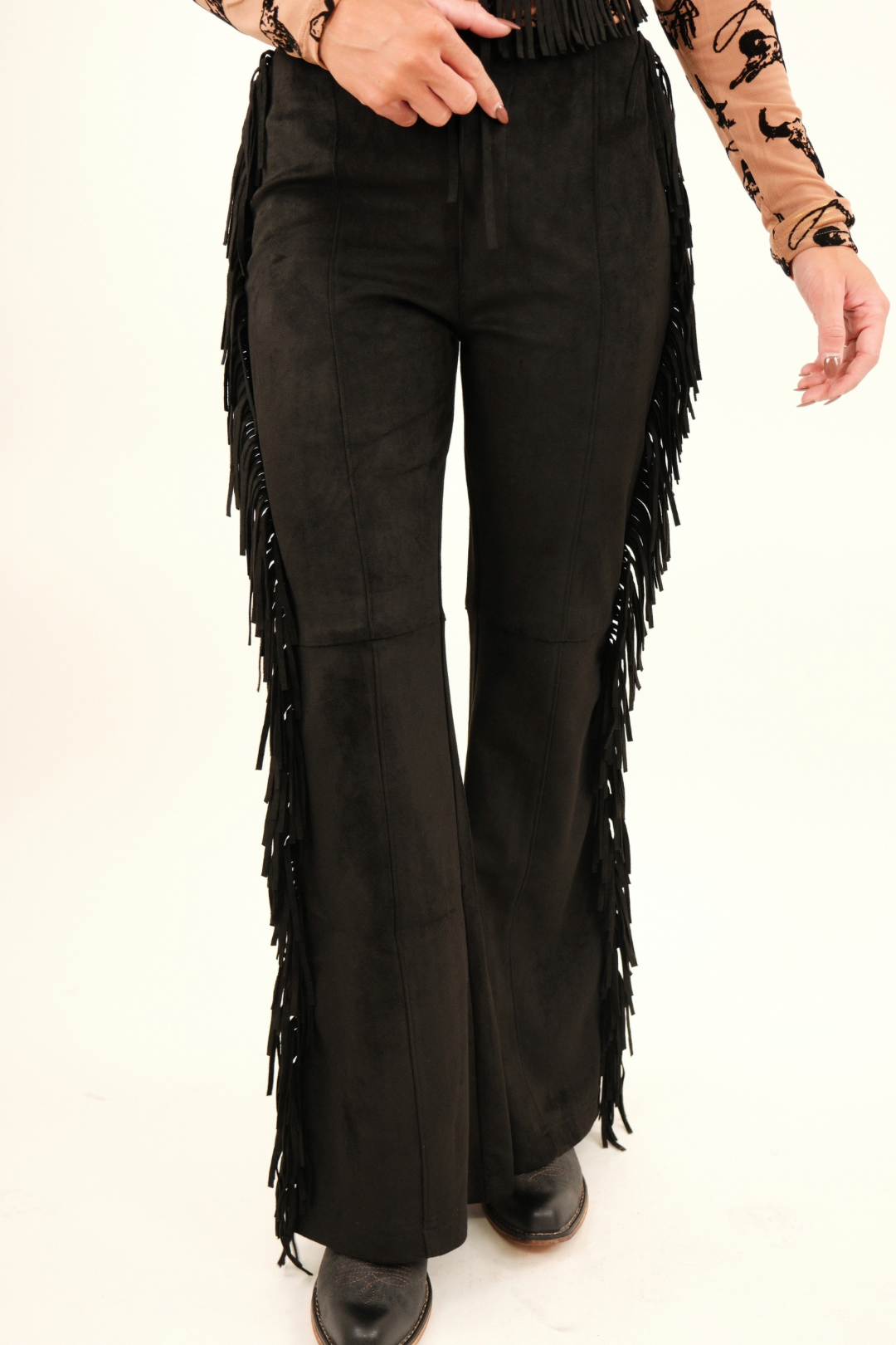 Close-up of Midnight Fringe Suede Pants highlighting luxe suede texture and bold fringe trim running down the side seam.