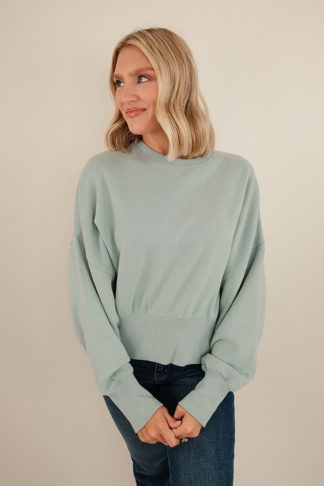 Sky blue waist-length fleece with mock neck and soft brushed texture, relaxed pullover style.