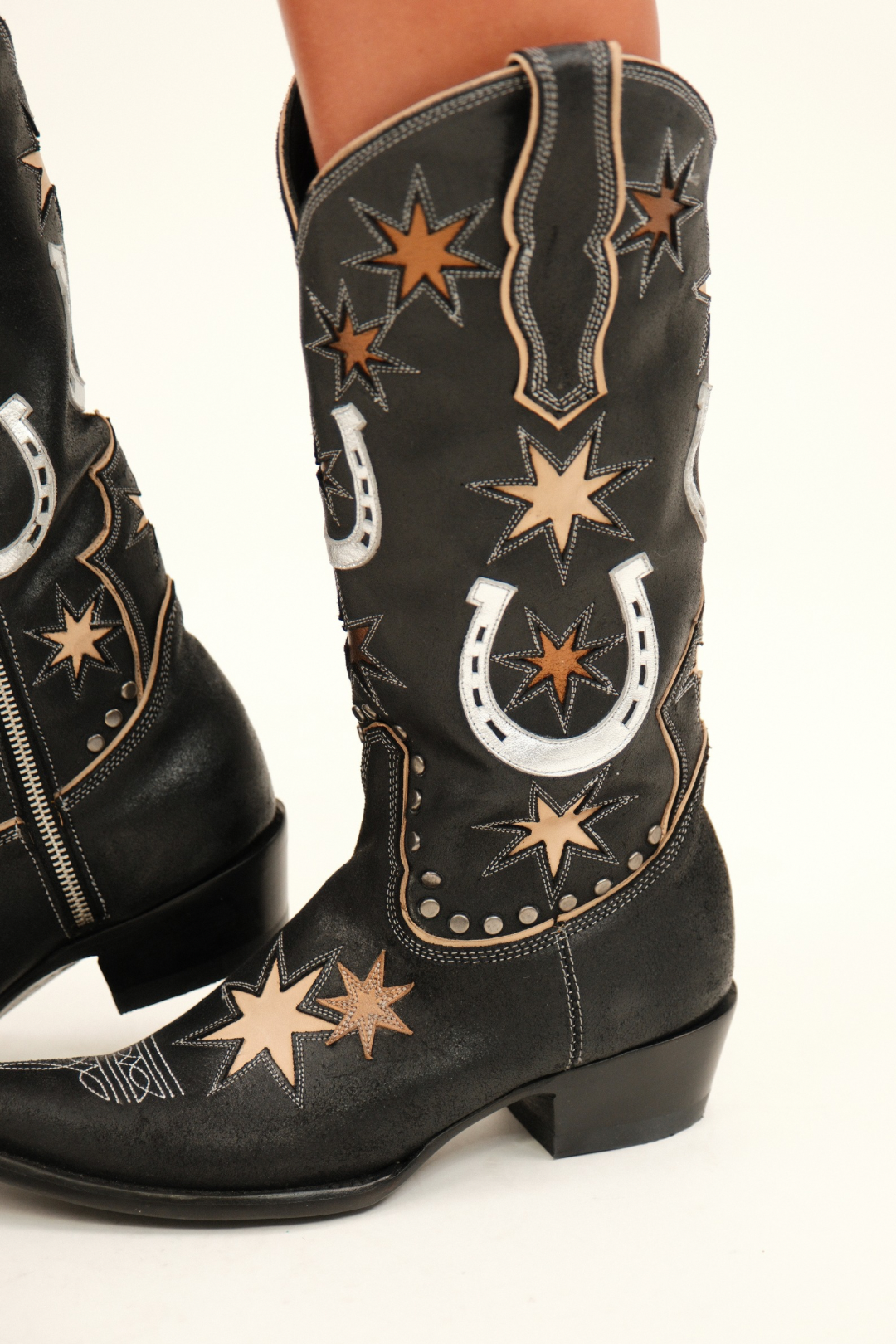 Close-up of Old Gringo Lucky Star boot shaft with metallic bronze stars, silver horseshoe designs, and fine stud accents on black leather.