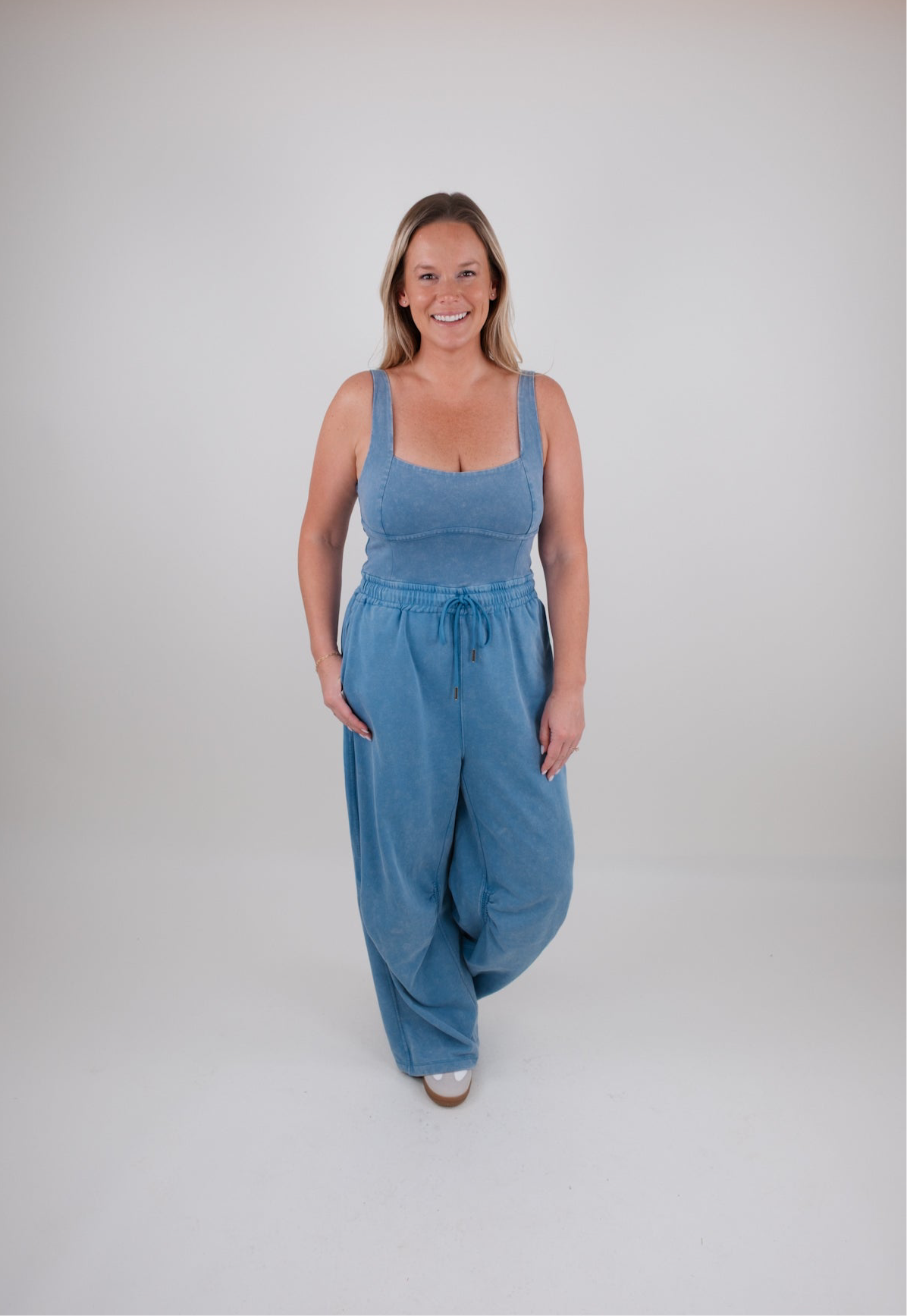 Woman wearing a blue jumpsuit on a white background
