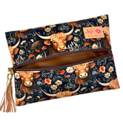 Front view of Prairie travel bag with black floral‑western Highland cow print on velvet, black zipper and gold tassel accent.