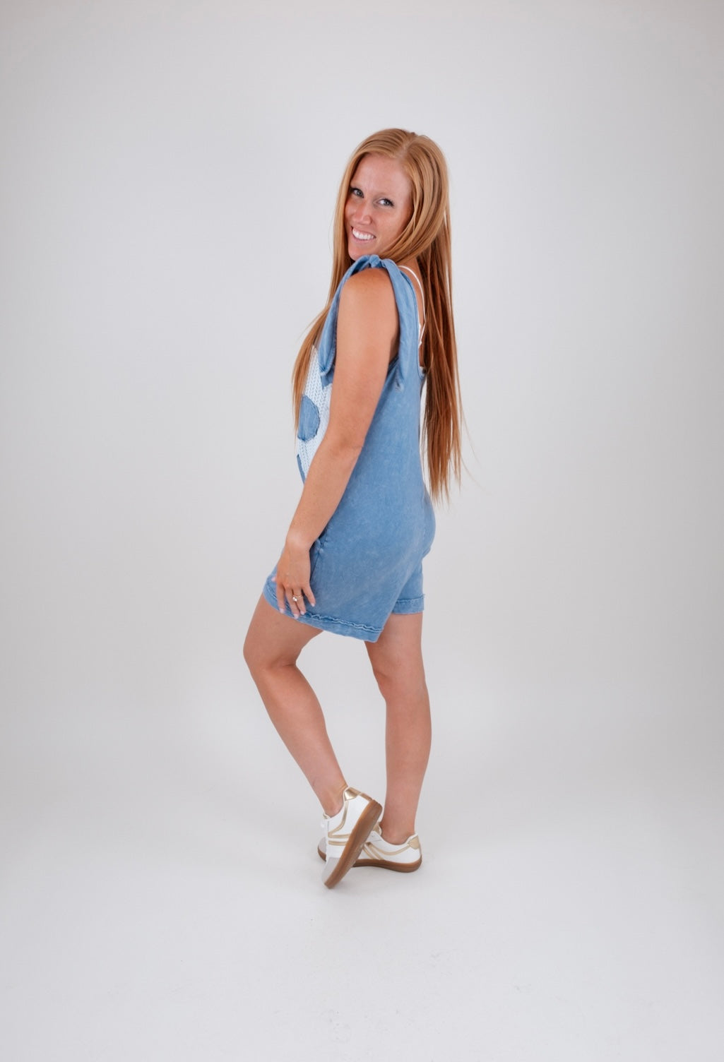 Woman wearing a denim romper on a white background
