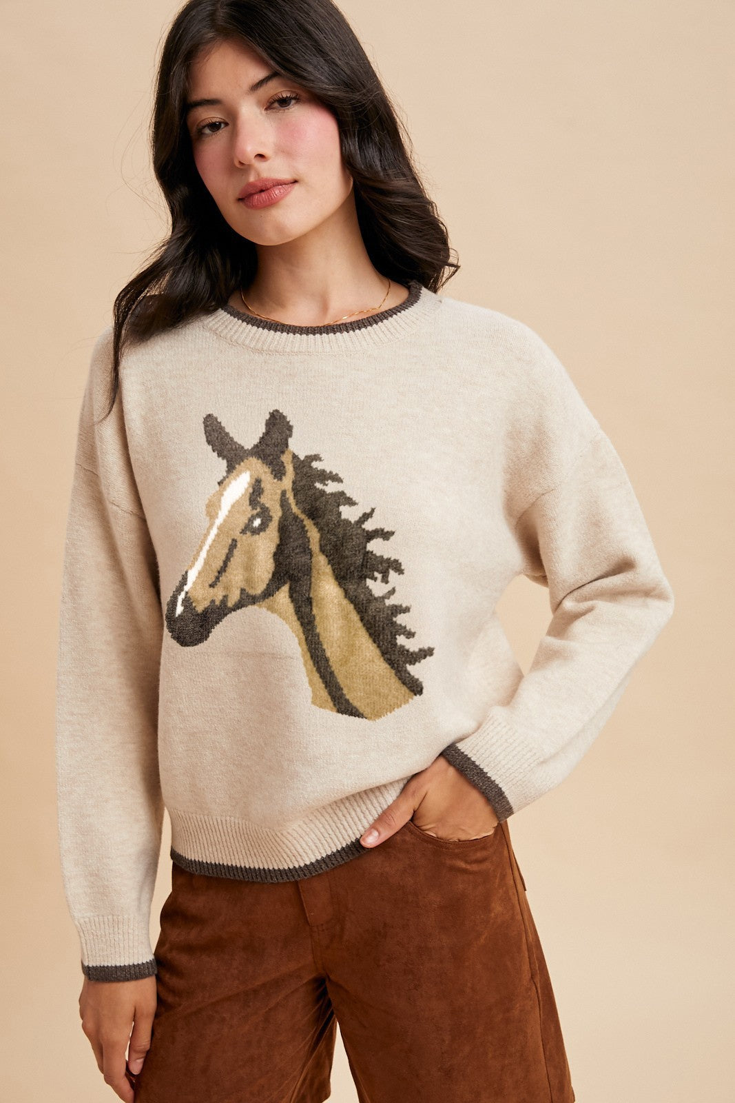 Front view of Prairie Pony Sweater, soft oatmeal knit with brown trim and detailed pony head design on chest for classic western style.