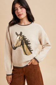 Front view of Prairie Pony Sweater, soft oatmeal knit with brown trim and detailed pony head design on chest for classic western style.