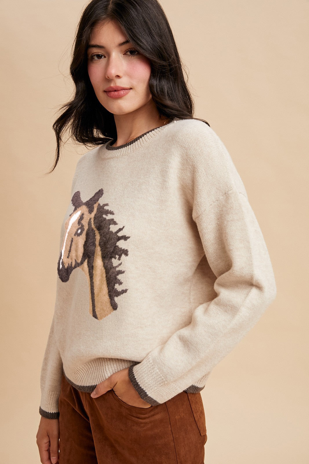 Side profile of Prairie Pony Sweater showing oatmeal knit texture, brown trim at neckline and cuffs, and cozy western silhouette.