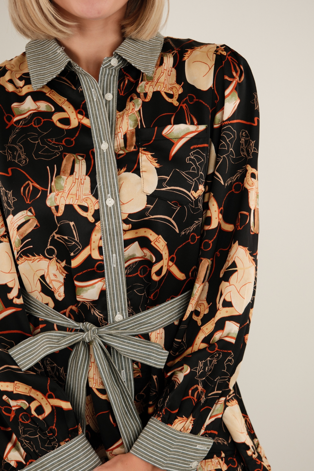 Side profile of black Rodeo Rendezvous Mini Dress showing long puff sleeves, striped cuffs, and belted waist for feminine cowgirl style.